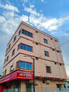 un edificio rosa con un cartello sul lato di Saha Guest House & Restaurant a Krishnanagar