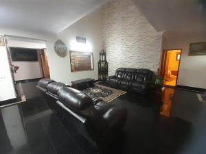 a living room with leather furniture and a brick wall at Spring Valley Villa in Bangalore