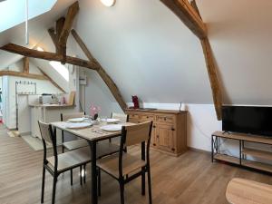 a dining room with a table with chairs and a tv at Appartement moderne proche centre Beauvais AB in Beauvais