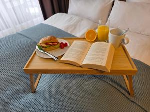 a coffee table with a sandwich and a book and orange juice at Ferienwohnung Fichtenzauber mit Balkon, nahe Bikepark & Skipiste in Winterberg