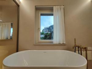a large white tub in a bathroom with a window at Dimora de Feo in Amalfi +70 photos