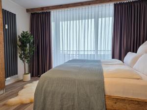 a bedroom with a large bed and a large window at Ferienwohnung Fichtenzauber mit Balkon, nahe Bikepark & Skipiste in Winterberg