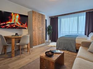 a bedroom with a bed and a living room with a fireplace at Ferienwohnung Fichtenzauber mit Balkon, nahe Bikepark & Skipiste in Winterberg
