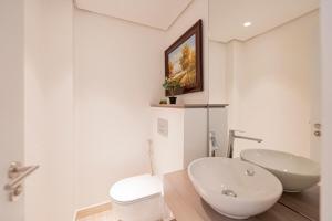 a white bathroom with a sink and a toilet at Ayla Oasis Golf Apartment - Ayla Vista in Aqaba +9 photos