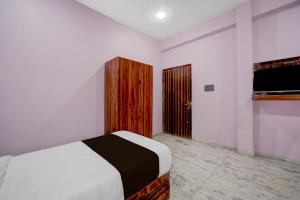a bedroom with a bed and a wooden door at Hotel O G9 in Indore