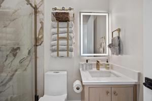 a bathroom with a toilet and a sink and a mirror at Festive Villa 1 Heart of Richardson TX 6BR 5BA in Richardson +44 photos