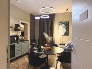 a room with a table and chairs and a kitchen at Chiara Home in Udine
