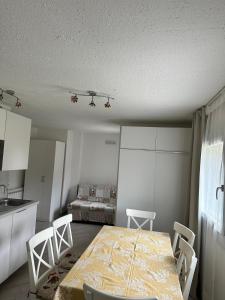 a kitchen with a table and chairs and a bed at Snow Sky in Passo del Tonale