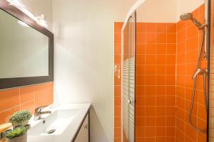 an orange tile bathroom with a sink and a shower at Maison Ponton - Logement familial avec accès privatif au lac in Veyrier-du-Lac +18 photos