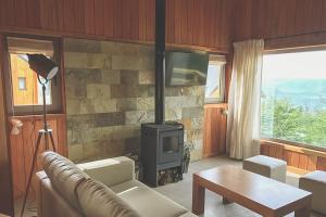 Una sala de estar con un sofá y una estufa. en Bosque Nevado, en San Martín de los Andes 13 fotos más
