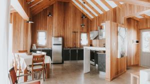 a kitchen with wooden walls and a table with chairs at Bosque Nevado in San Martín de los Andes