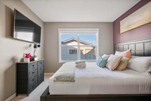 sypialnia z dużym łóżkiem i oknem w obiekcie Family Home 4BR - Near Airport! FREE Banff Pass - BBQ - Netflix - Gym - Games! w mieście Calgary