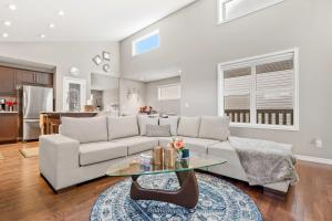 salon z kanapą i stołem w obiekcie Family Home 4BR - Near Airport! FREE Banff Pass - BBQ - Netflix - Gym - Games! w mieście Calgary +44 zdjęcia