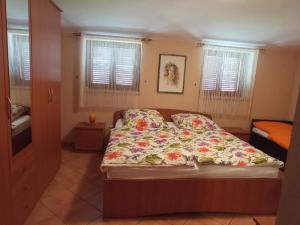 a bedroom with a bed with a floral bedspread at Apartments Judit in Tar