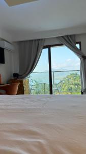 Un dormitorio con una cama y una ventana grande. en Résidence Kazela, en Chirongui
