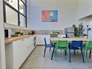 a kitchen with a wooden table and blue chairs at Pop Centre in Valence