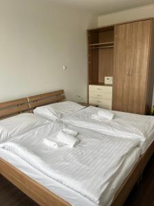 uma cama com duas toalhas brancas em cima em Fine Restaurant & Apartments em Malacky