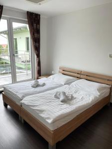 um quarto com uma cama com lençóis brancos e uma janela em Fine Restaurant & Apartments em Malacky