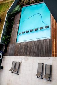 a group of three chairs sitting in front of a swimming pool at The Cozy Maldives in Durban
