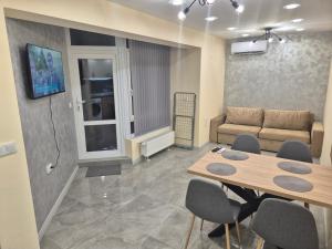 a living room with a table and chairs and a couch at Apartment The Garden in Ruse