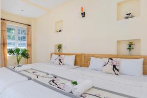 two beds in a room with white walls at Biệt thự hồ bơi cho du khách bãi sau in Vung Tau +37 photos