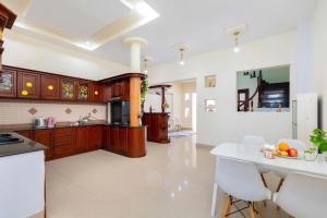 a kitchen with wooden cabinets and a white floor at Biệt thự hồ bơi cho du khách bãi sau in Vung Tau