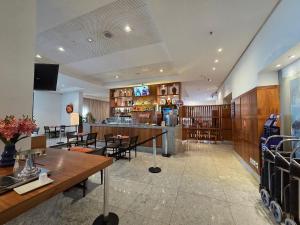 een restaurant met een bar en een aantal tafels en stoelen bij Beach Class Executive por Yolo in Recife
