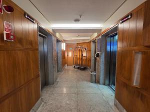 een gang in een gebouw met houten wanden en een lift bij Beach Class Executive por Yolo in Recife