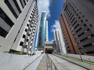a walkway in a city with tall buildings at Beach Class Executive por Yolo in Recife