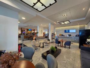 a lobby with chairs and tables and a bar at Beach Class Executive por Yolo in Recife
