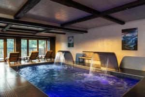 a large indoor pool with a table and waterfalls at Black Diamond - Tignes in Les Brévières