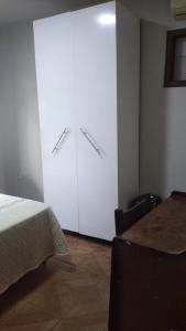 a bedroom with a bed and a large white closet at Aconchego I in Foz do Iguaçu