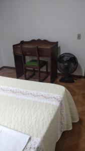 a bedroom with a desk and a chair and a bed at Aconchego I in Foz do Iguaçu