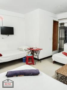 a hotel room with two beds and a desk at Hotel Rose International in Dhaka +14 photos