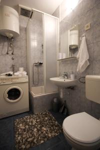 a bathroom with a toilet and a sink and a washing machine at Apartment Gabrijela in Split
