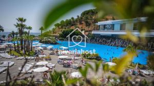 a resort with a swimming pool with people and umbrellas at The Mills Santa Cruz, by Nivariahost in Santa Cruz de Tenerife