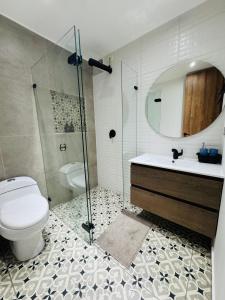 une salle de bain avec toilettes, lavabo et miroir dans l'établissement Luxury Room en Las Quintas, à Tunja