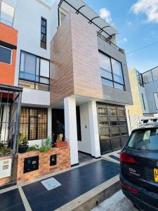 une maison avec une voiture garée devant dans l'établissement Luxury Room en Las Quintas, à Tunja