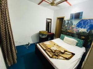 a bedroom with a bed with a blue floor at Lux Lodges Guest House in Islamabad +2 photos