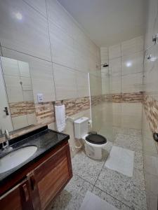 a bathroom with a toilet and a sink and a shower at Pousada Kalango Flecheiras in Trairi +8 photos