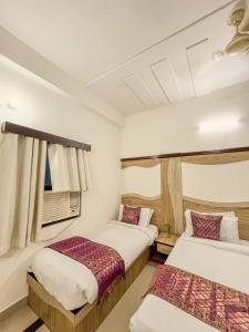 ein Schlafzimmer mit zwei Betten und einem Fenster in der Unterkunft The Golden Hotel Agra in Tājganj