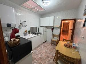 a kitchen with a table and a kitchen with white cabinets at Nobleza Nava del Rey in Nava del Rey