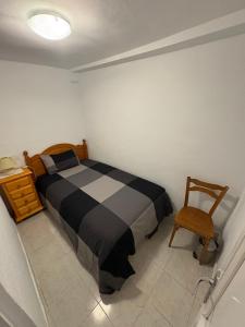 a bedroom with a black and white bed and a chair at Nobleza Nava del Rey in Nava del Rey +3 photos