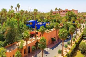 une vue aérienne d'un complexe hôtelier avec des palmiers dans l'établissement Appartement Luxe 2 Chambres Vue Directe Jardin Majorelle YSL, à Marrakech