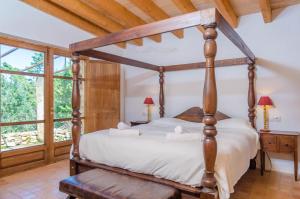 a bedroom with a four poster bed and a window at Villa Es Molí des Trenc in Colònia De Sant Jordi +42 photos
