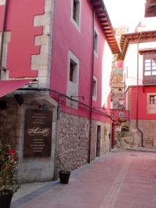 um edifício com tinta rosa na lateral em Pensión Arbidel em Ribadesella