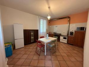 una cucina con tavolo bianco e sedie rosse di Teseo a Ca Vecchia