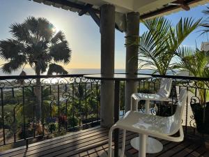 a balcony with a table and chairs and a view of the ocean at Sunset View by JuMa in Rivière Noire