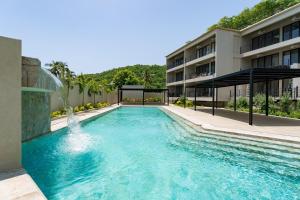 une piscine avec une fontaine en face d'un bâtiment dans l'établissement 3065 - Solana A208, à Santa Cruz Huatulco