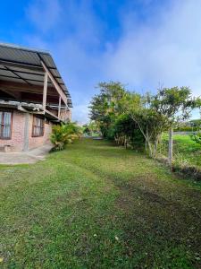 a grassy yard next to a brick building at Villa Daniela Restrepo in Restrepo